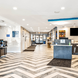 new brightly lit lobby with striped floors and cream walls